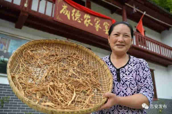 神山村村民彭夏英在自己開的農(nóng)家樂前展示自家的農(nóng)產(chǎn)品