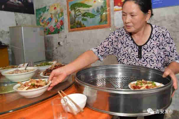 神山村村民彭夏英在自己開的農(nóng)家樂給游客上菜